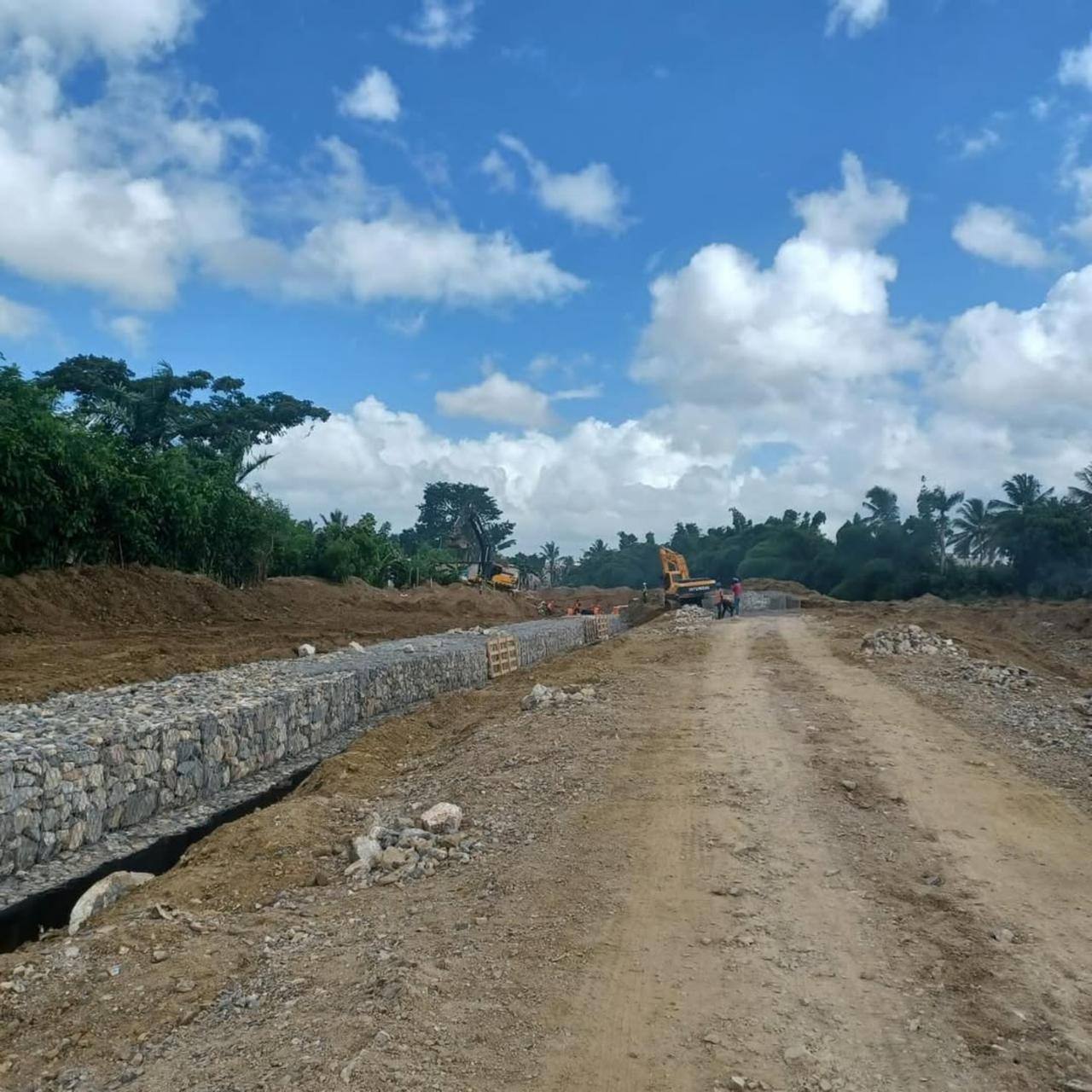 Tramo de muro terminado con maquinaria al fondo